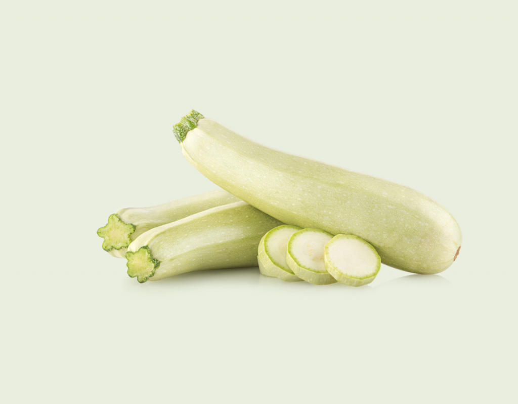 Calabacines verdes con varias rodajas sobre fondo claro